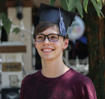 Boy wearing graduation cap and smiling